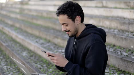 Man-smiling-and-texting-via-smartphone